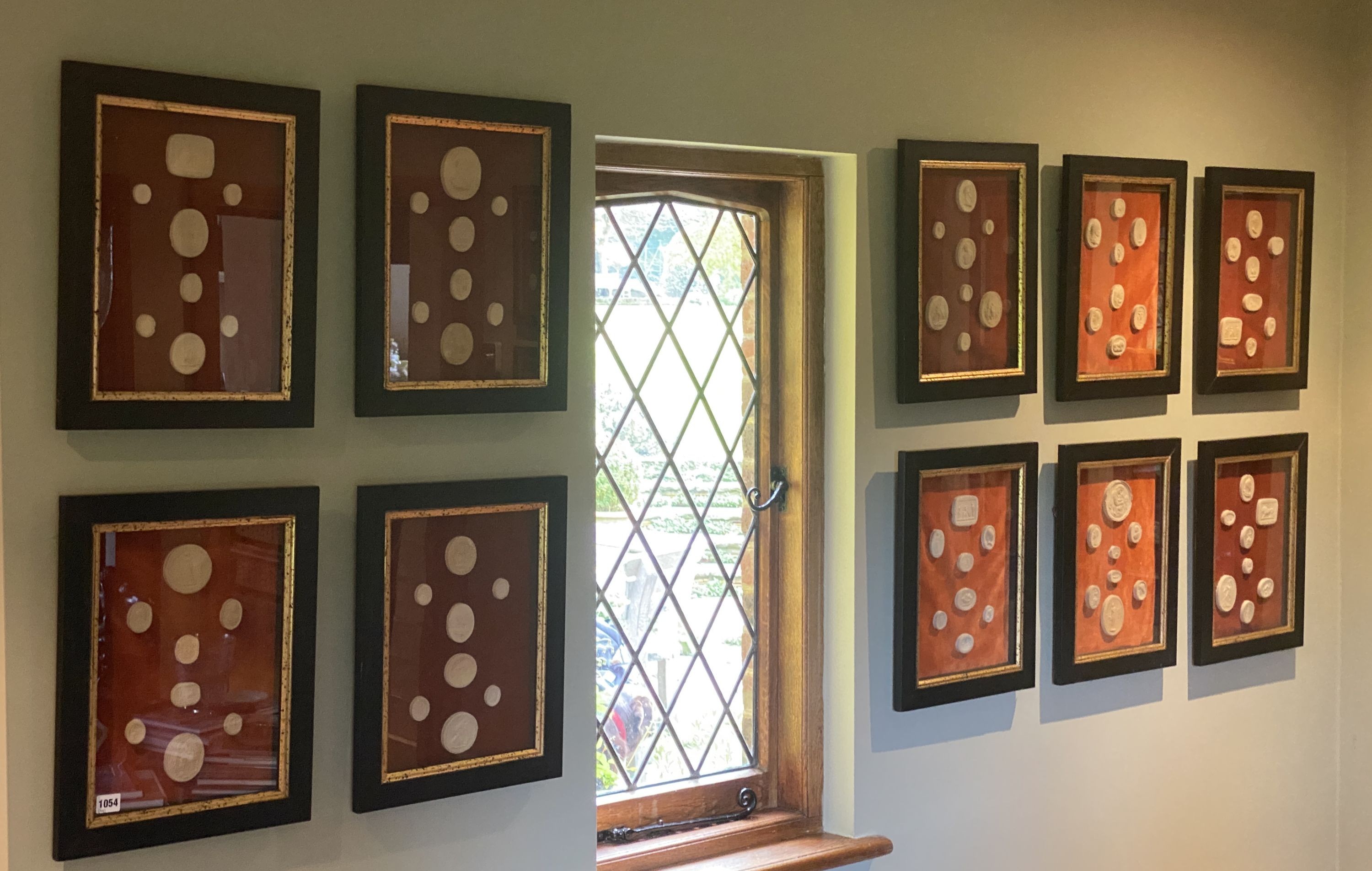 A collection of thirty four framed reproduction plaster intaglios, on velvet backing with parcel gilt ebonised frames, overall 45 x 35cm